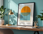 Framed Bauhaus poster on a desk with a lamp and plants against a teal wall.