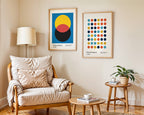 Living room with a beige armchair, wooden coffee table, and side table with a plant, featuring two framed artworks on the wall.