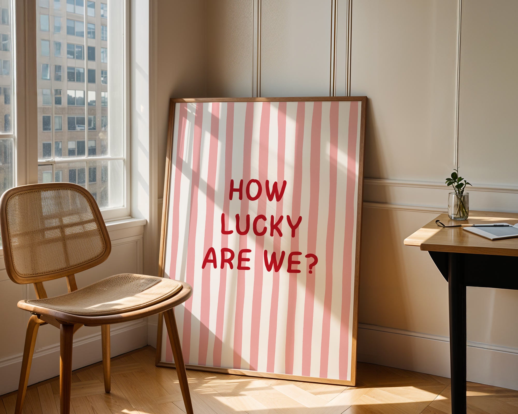 Framed picture with 'How Lucky Are We?' text in a room with a chair and table.