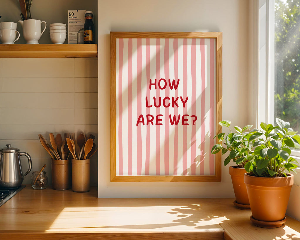 Framed print with 'How Lucky Are We?' text in a kitchen setting