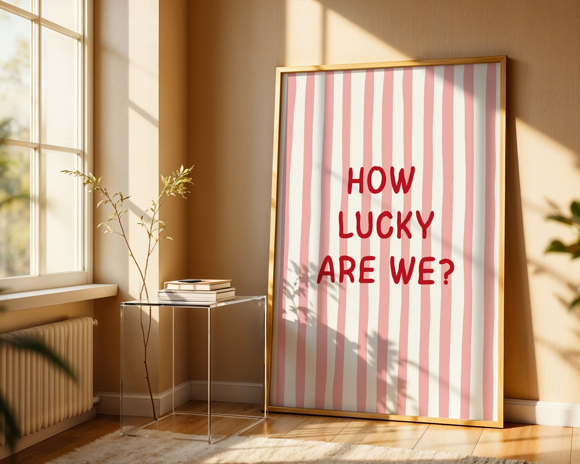 Framed artwork with 'HOW LUCKY ARE WE?' text on a striped background in a sunlit room.