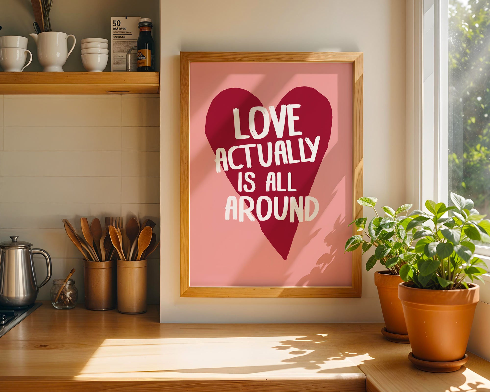 Framed poster with 'Love actually is all around' quote in a kitchen setting