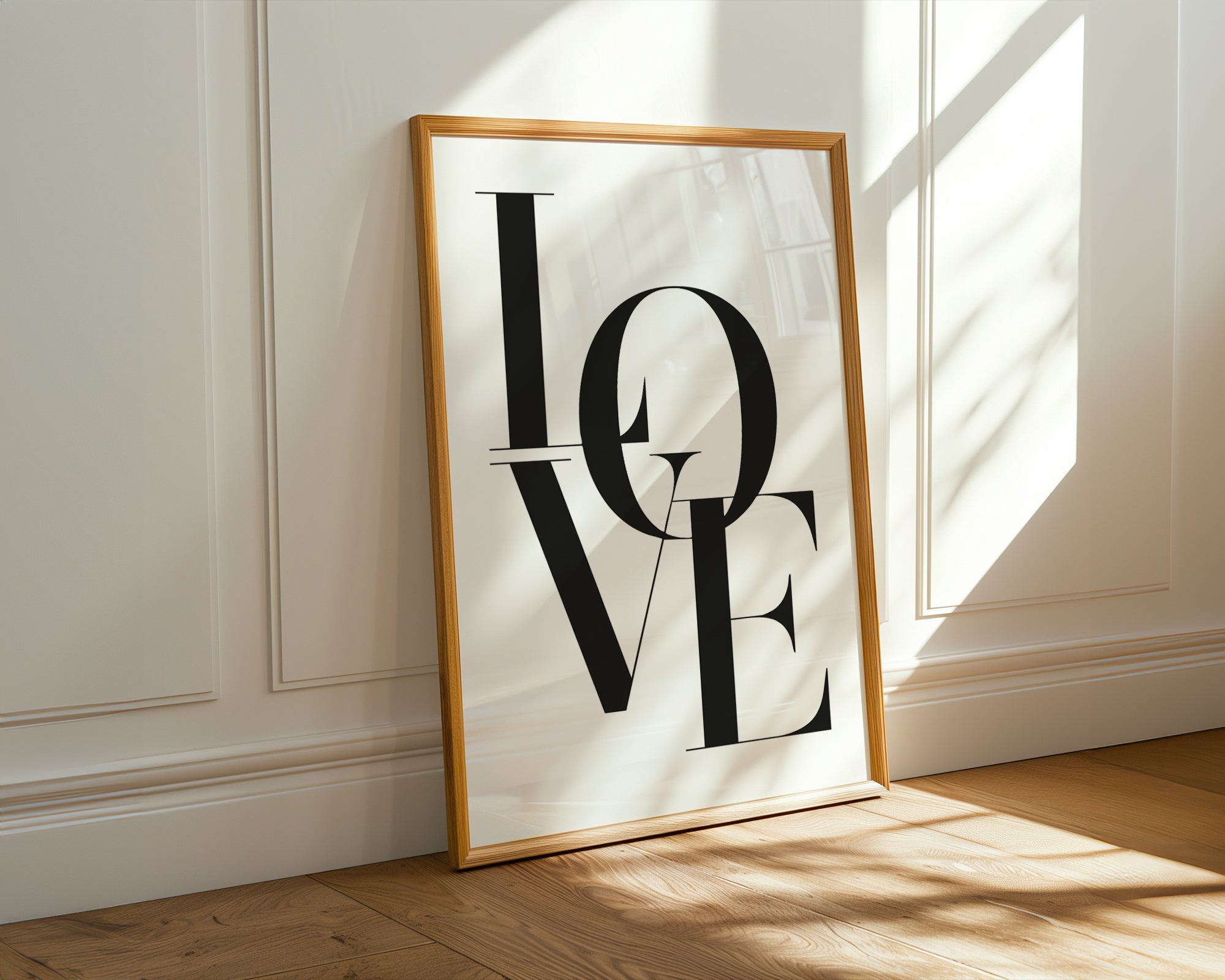 Framed artwork with 'LOVE' on a wall with sunlight casting shadows
