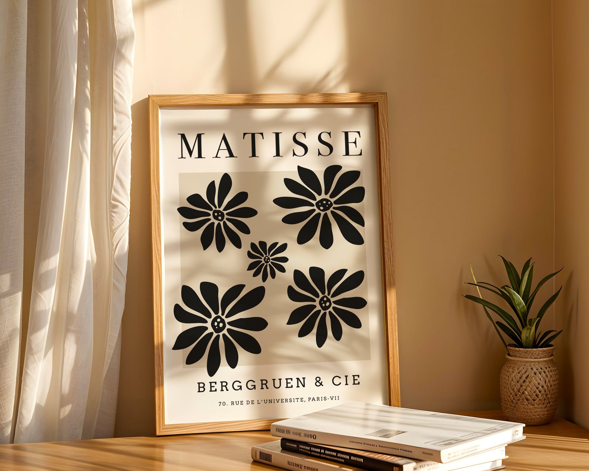 Framed Matisse poster with black floral designs on a beige wall.