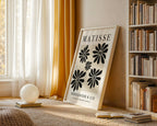 Framed artwork with floral design and text in a room with books and decor.