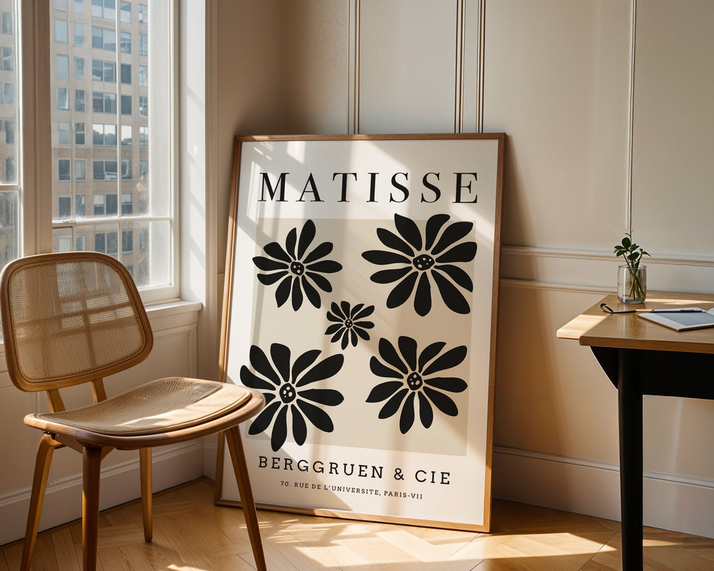 Framed Matisse poster in a room with a chair and table.