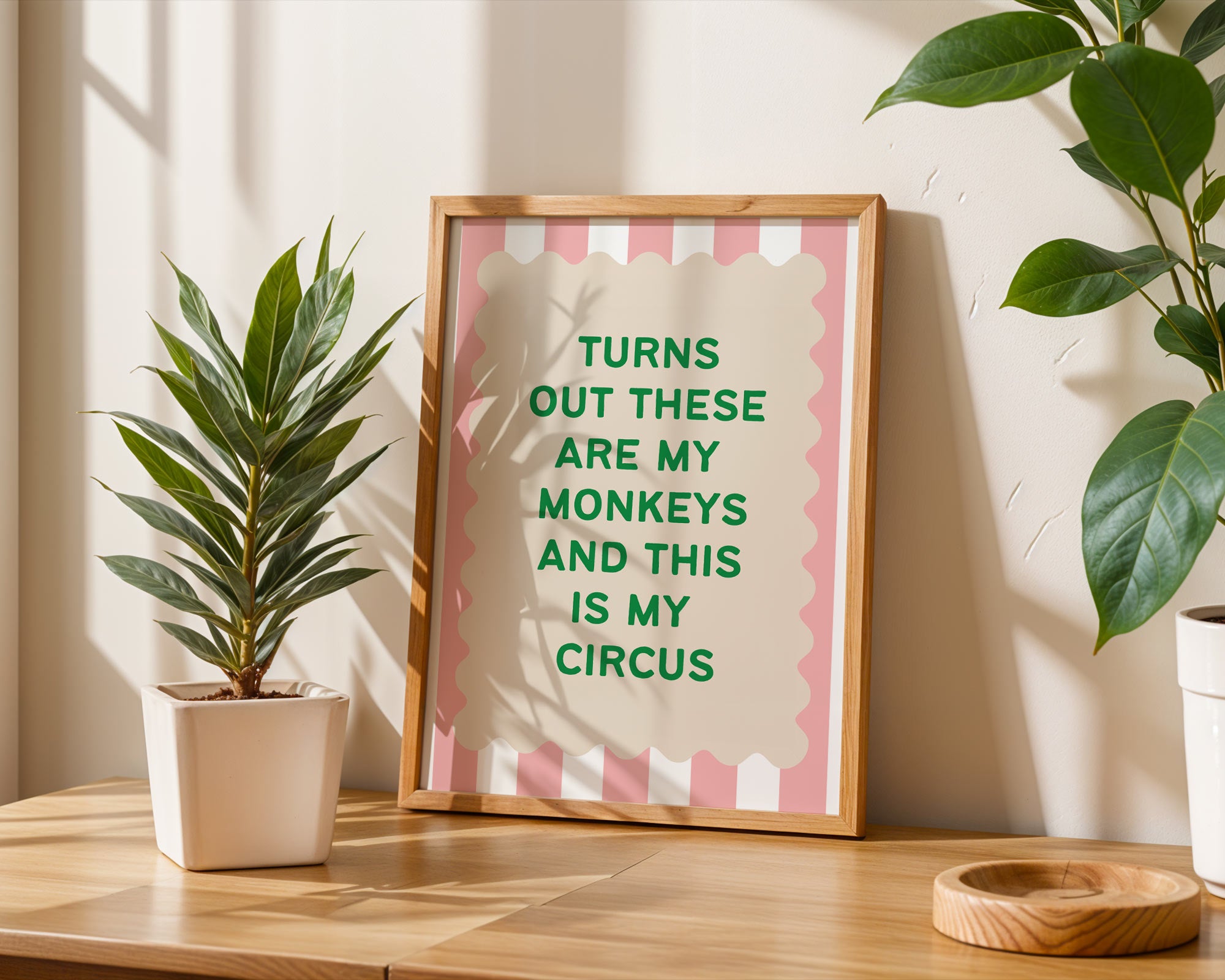 Framed quote on a wall with plants and a wooden surface