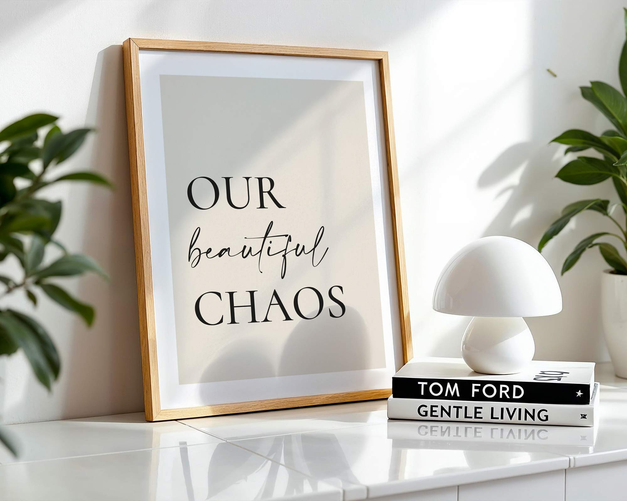 Framed print with 'Our beautiful chaos' text on a shelf with decor items.