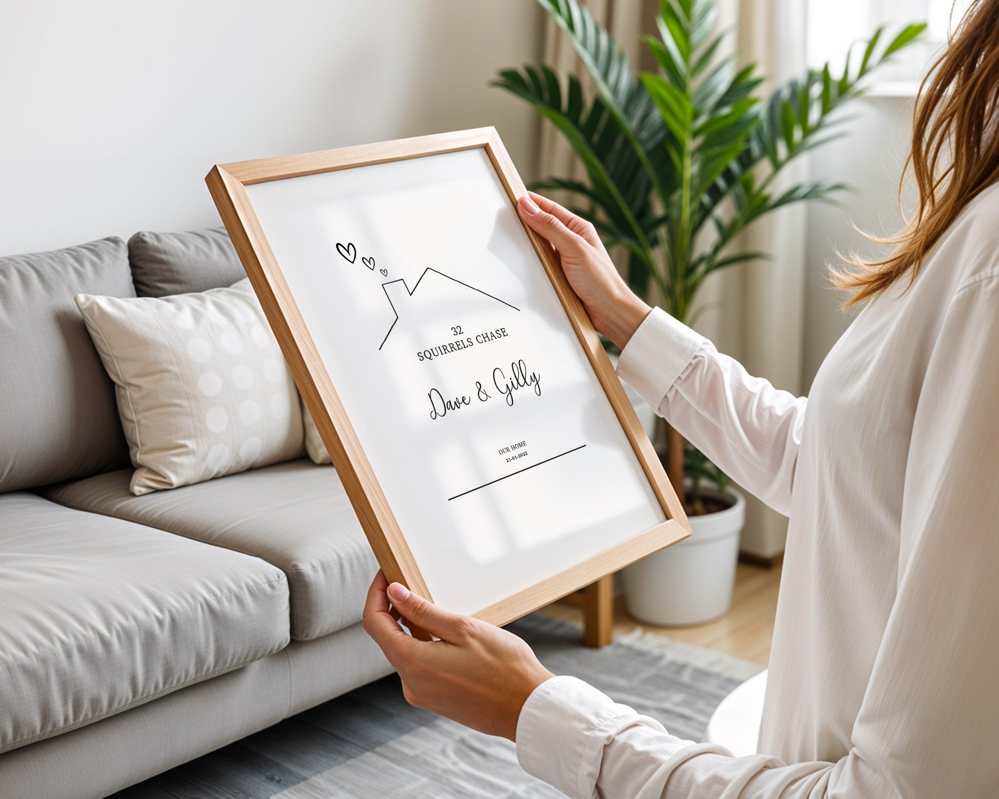Person holding a framed print in a living room