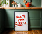 Kitchen setting with a framed poster asking 'What's for dinner?' on a green cabinet.