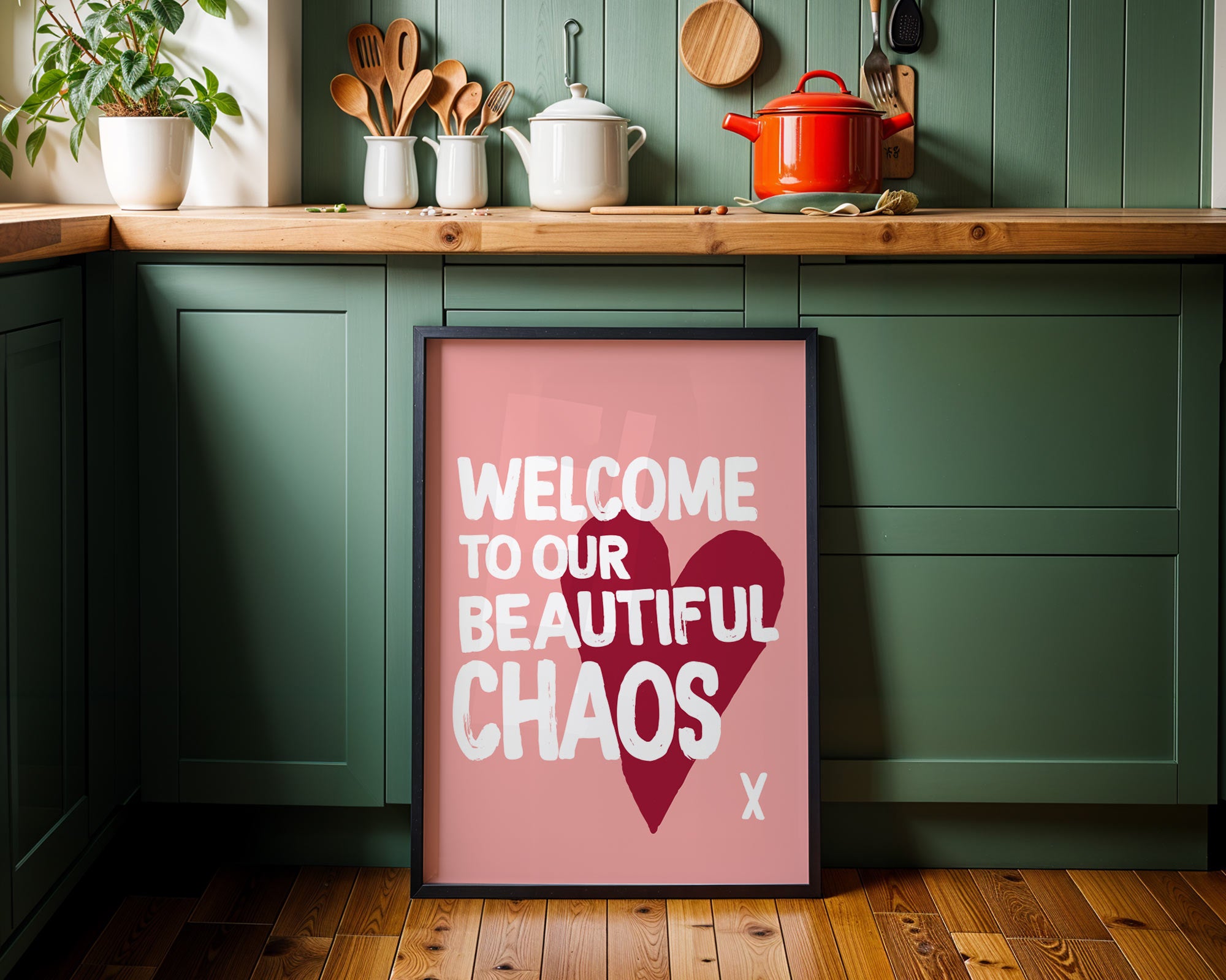 Framed poster with 'Welcome to our beautiful chaos' text in a kitchen setting