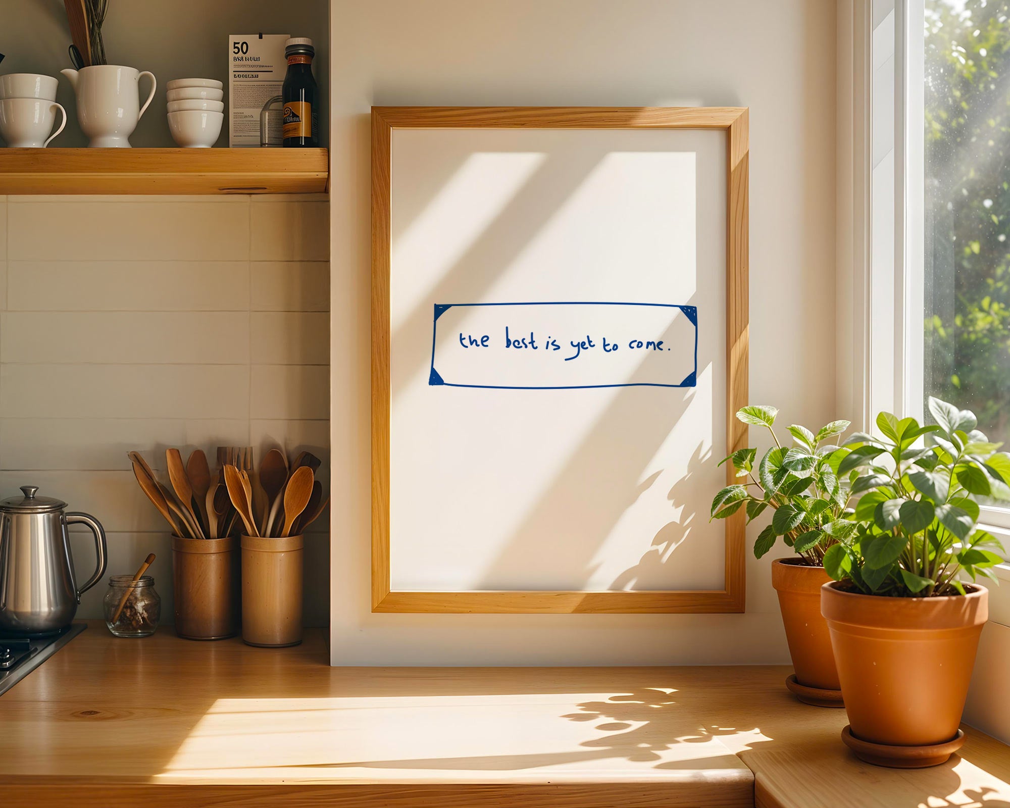 Kitchen counter with a framed quote, potted plants, and coffee cups.