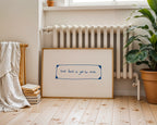 Framed artwork with inspirational quote on a wooden floor with radiator and plant in background