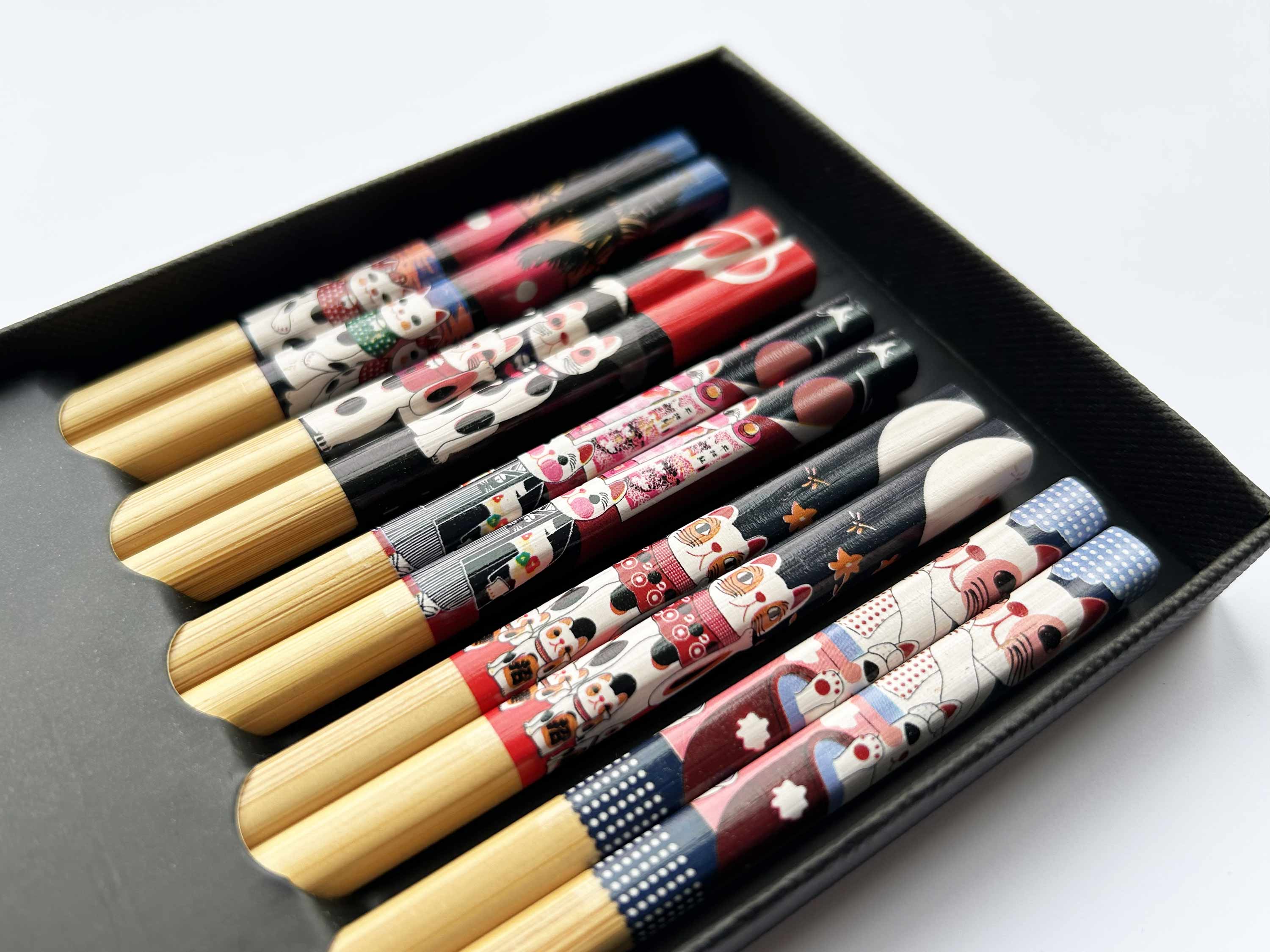 Set of decorative chopsticks in a black box on a light background