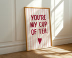 Framed print with 'You're my cup of tea' text on a striped background, placed against a white wall.