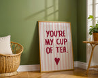 Framed print with 'You're my cup of tea' text in a room with a green wall and wooden floor.