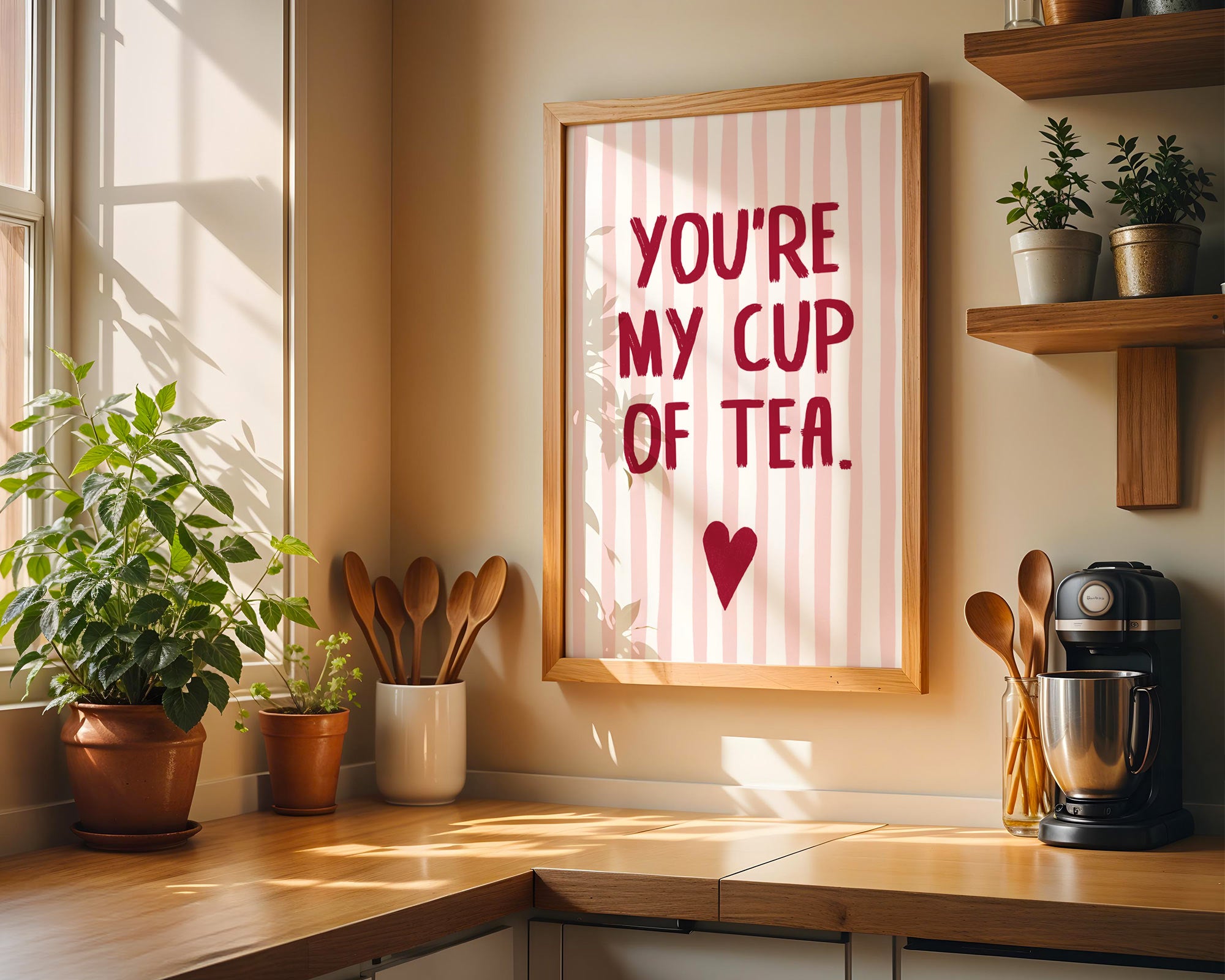Kitchen counter with a 'You're my cup of tea' sign, plants, and kitchen utensils.