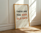 Framed poster with 'These are the good old days' text on a wall.