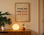 Framed artwork with motivational quote on a wall above a wooden cabinet with decorative items.