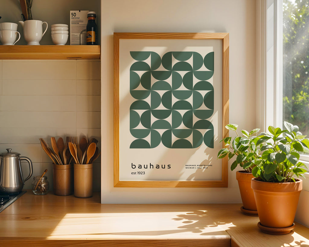 Framed Bauhaus poster on a kitchen wall with plants and kitchenware.