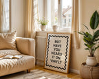 Living room with beige sofa, plant, and decorative sign.