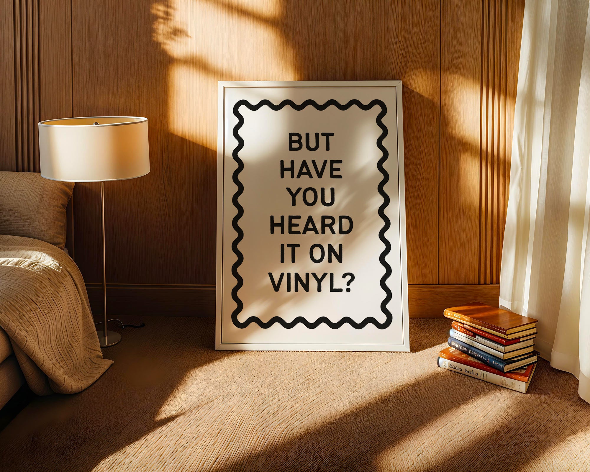 Framed poster with text 'BUT HAVE YOU HEARD IT ON VINYL?' in a room with a lamp and books.