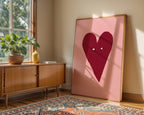 Room interior with a wooden sideboard, plant, and large pink heart artwork.