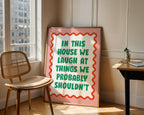 Framed sign with humorous quote in a room with a chair and window.