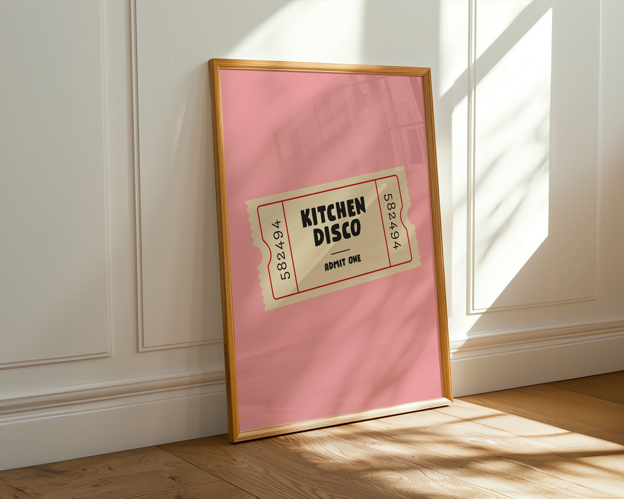 Framed pink poster with 'Kitchen Disco' text on a white wall.