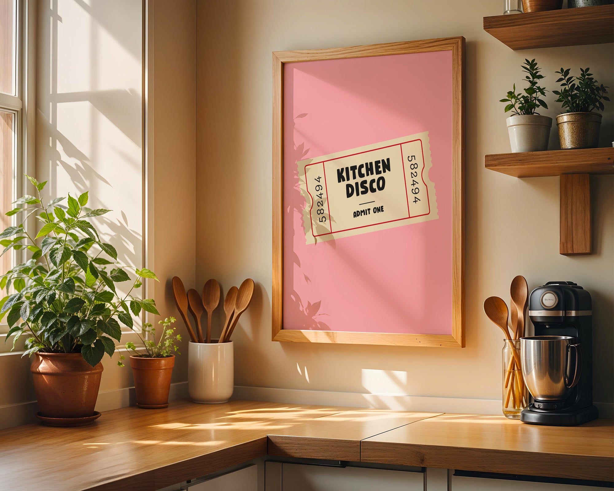 Kitchen with a framed poster titled 'Kitchen Disco' on the wall, wooden shelves with plants, and kitchen utensils.