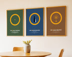 Three framed posters of 'The Lord of the Rings' series on a wall above a table.