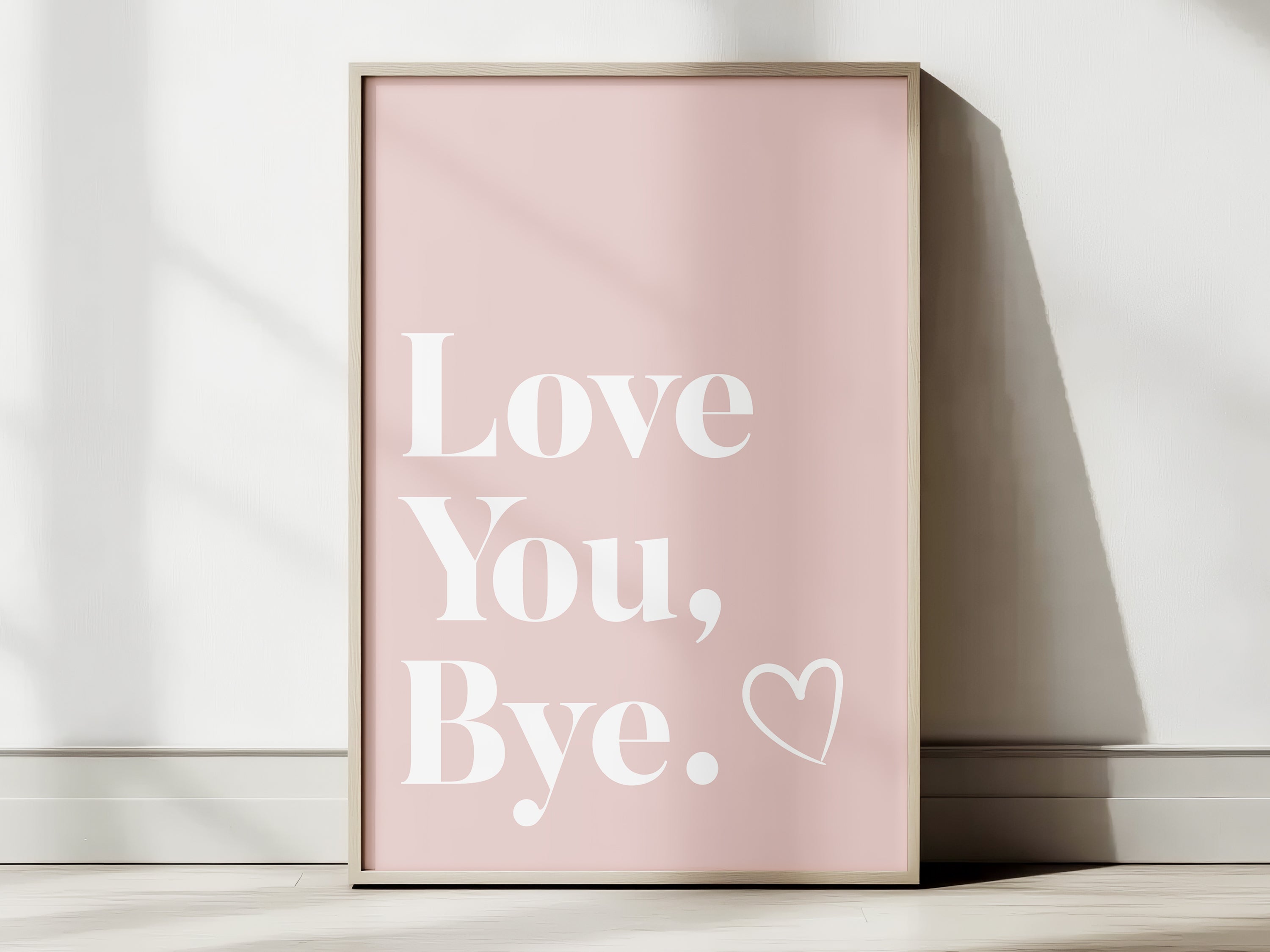Framed pink poster with 'Love You, Bye' text on a white surface