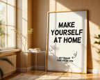 Framed poster with 'Make Yourself At Home' text in a sunlit room.