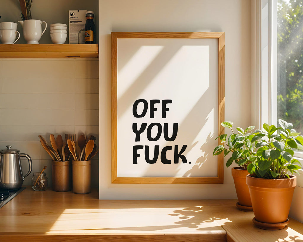Framed artwork with a bold text statement in a kitchen setting