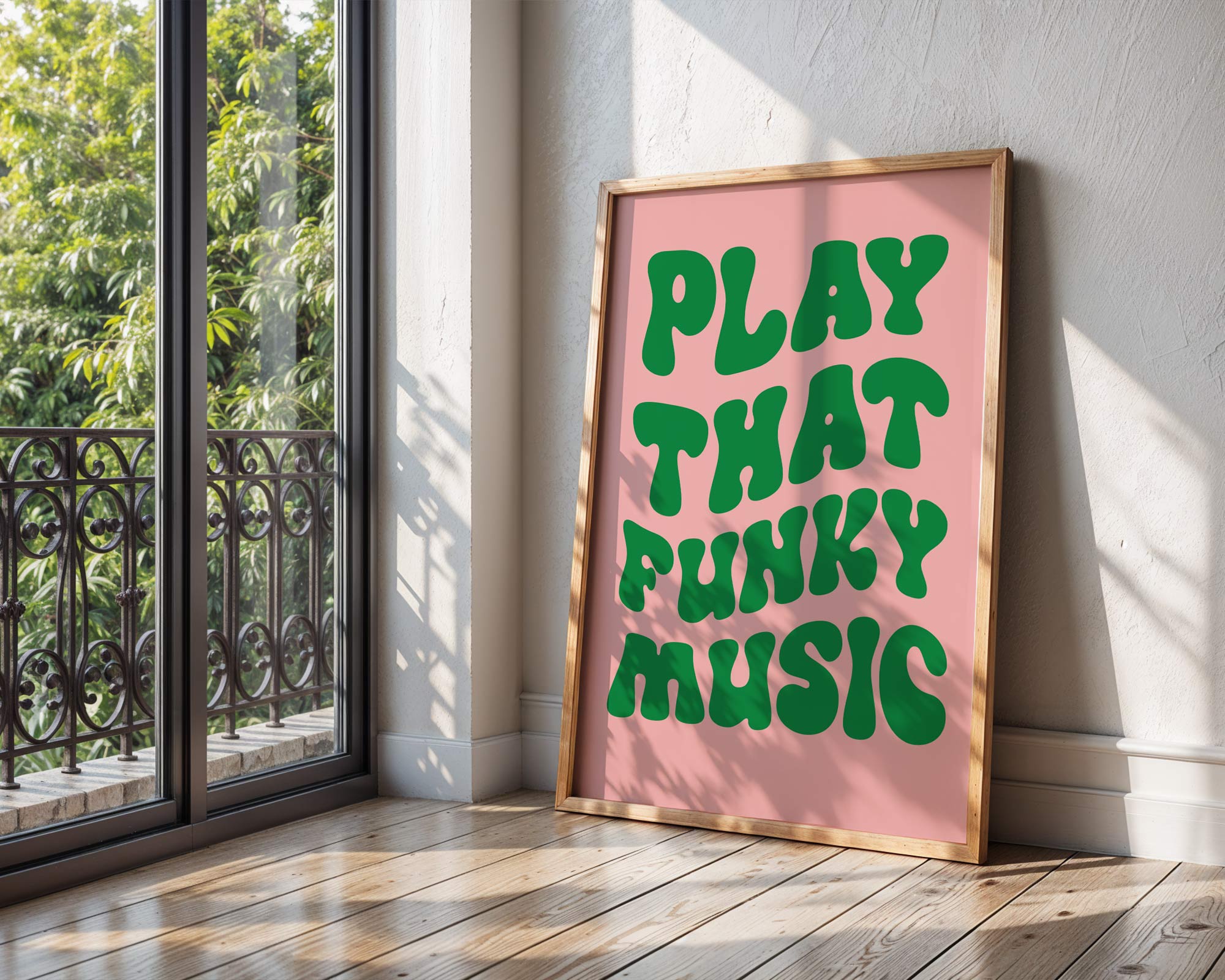 Framed poster with 'Play That Funky Music' text on a pink background, leaning against a wall next to a window.
