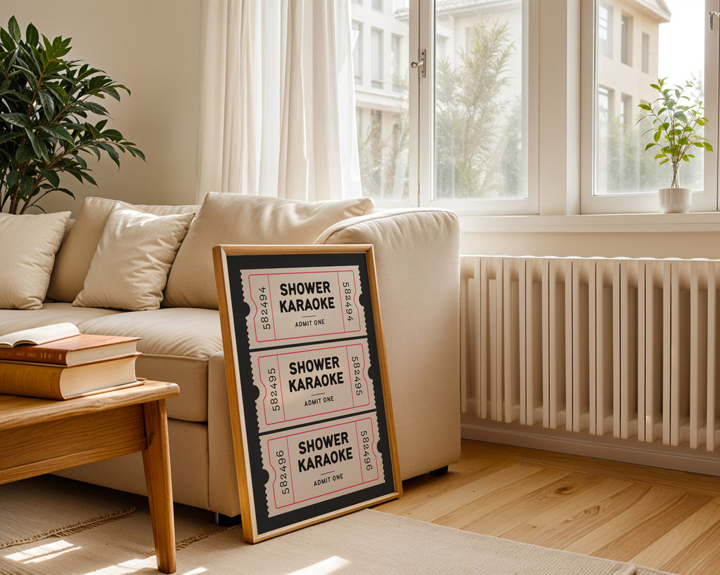 Framed 'Shower Karaoke' sign on a coffee table in a living room with a couch and plants.