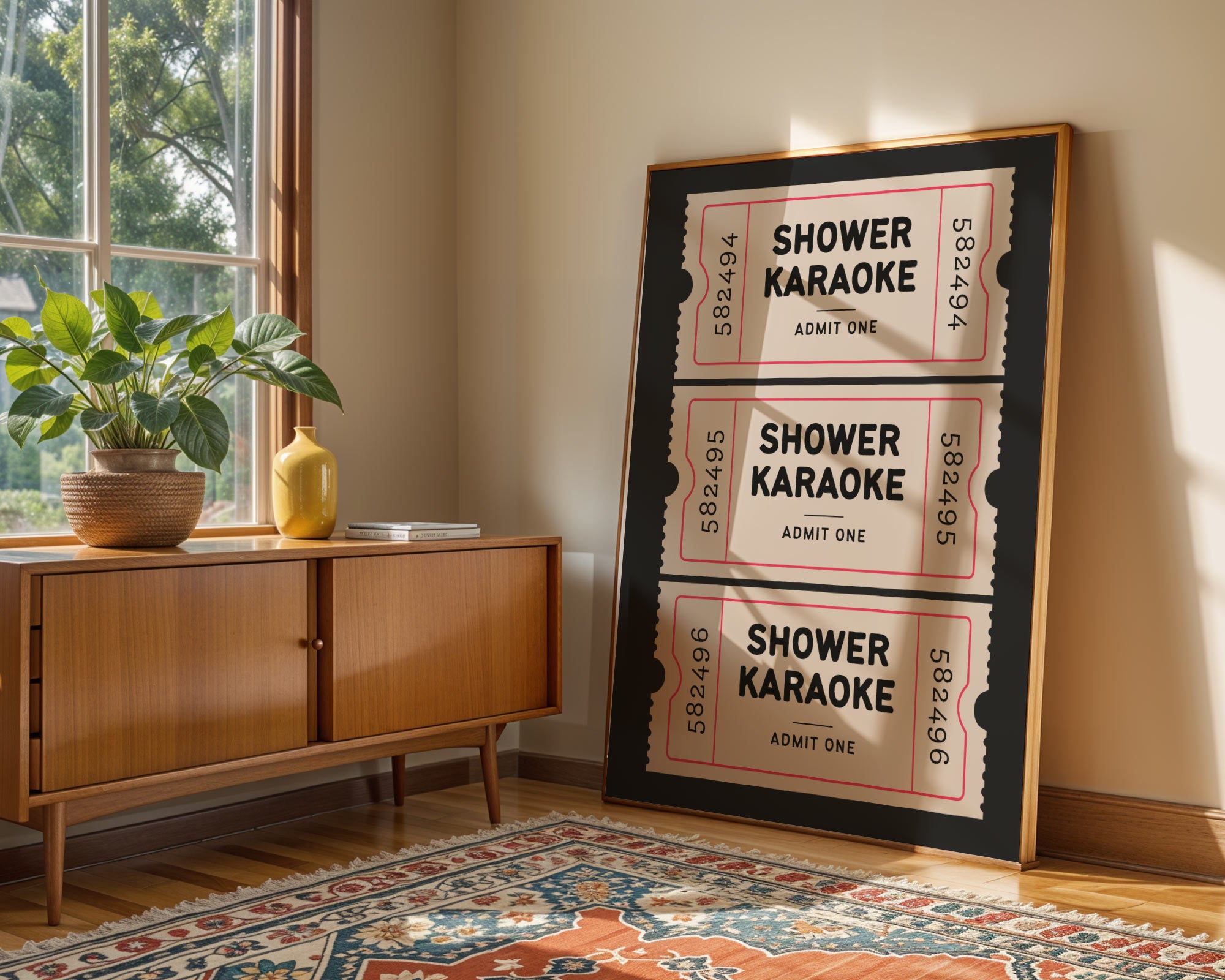 Framed 'Shower Karaoke' poster on a wall next to a wooden sideboard with a plant.