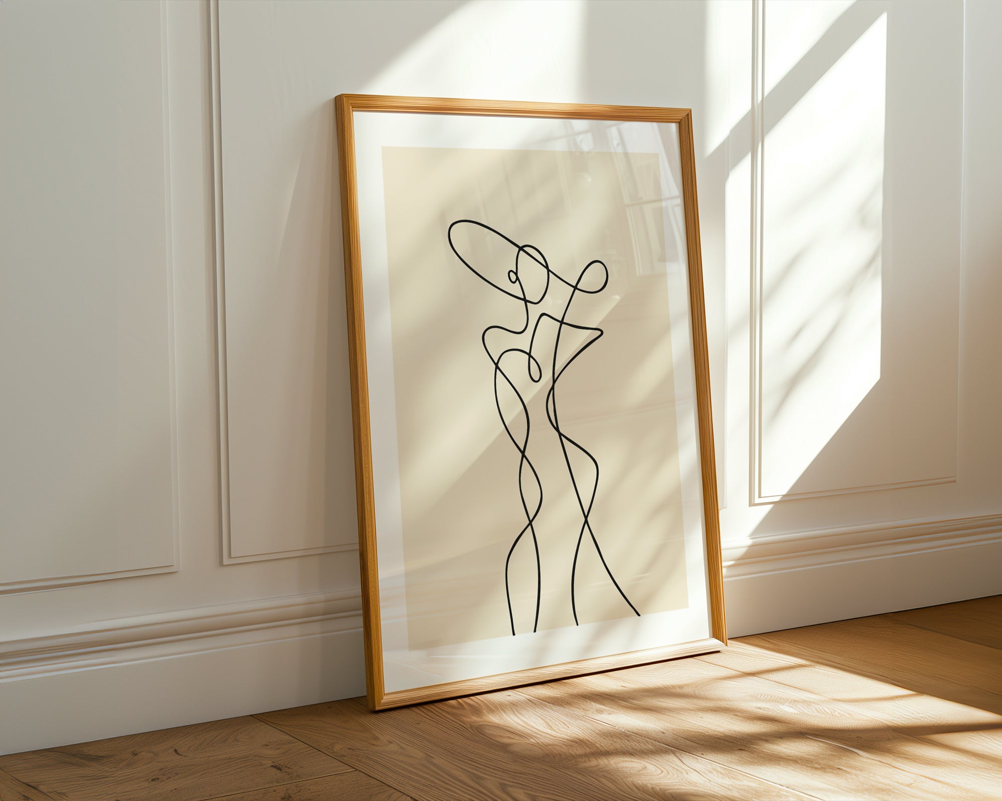 Framed line art of a nude figure on a white wall with natural light.