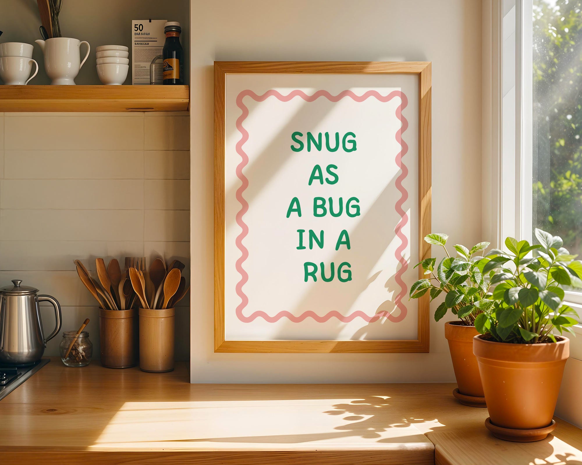 Framed print with 'Snug as a bug in a rug' text in a kitchen setting.