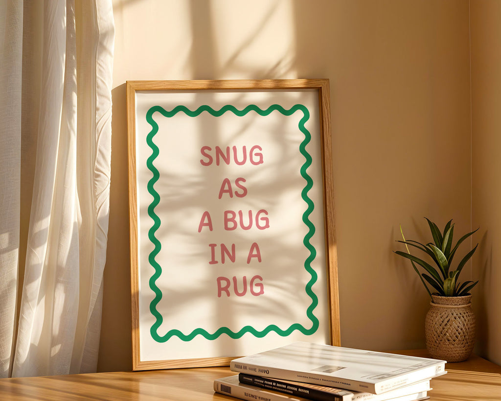 Framed print with 'Snug as a bug in a rug' text on a shelf with books and a plant.