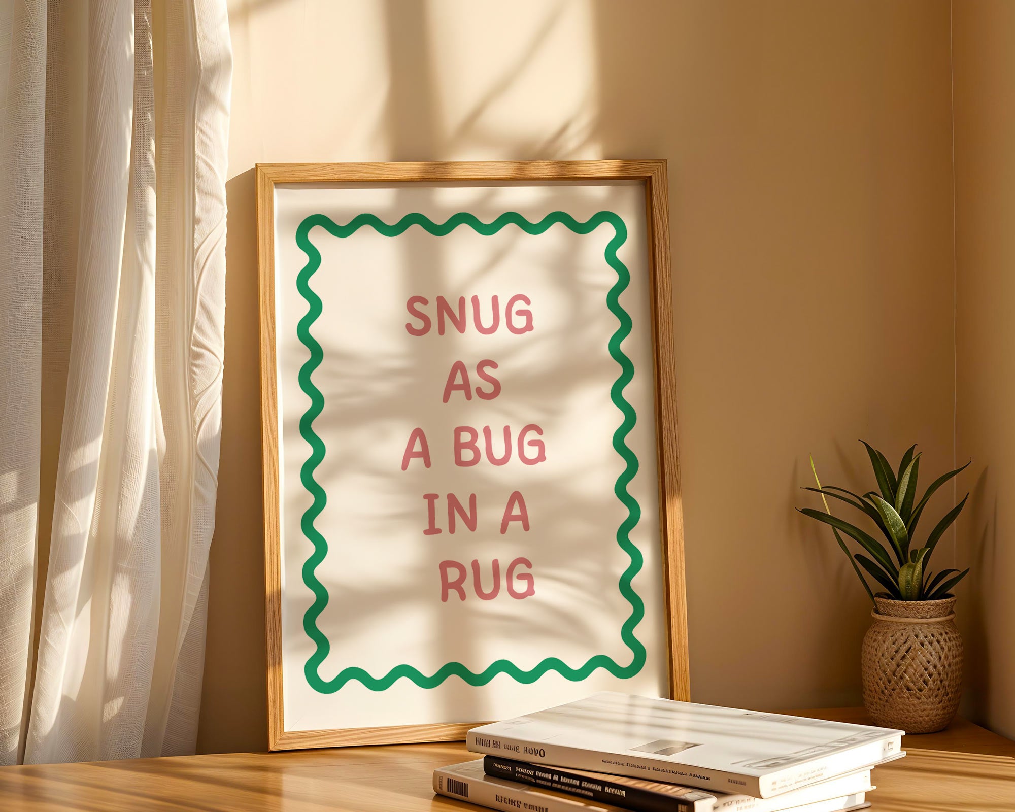 Framed print with 'Snug as a bug in a rug' text on a shelf with books and a plant.