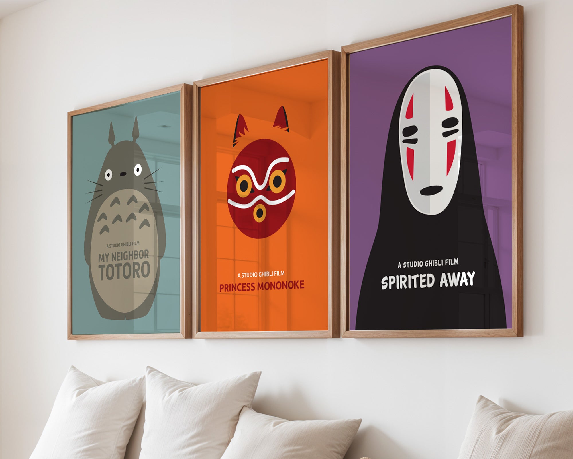 Three framed posters of animated characters on a wall above a sofa.