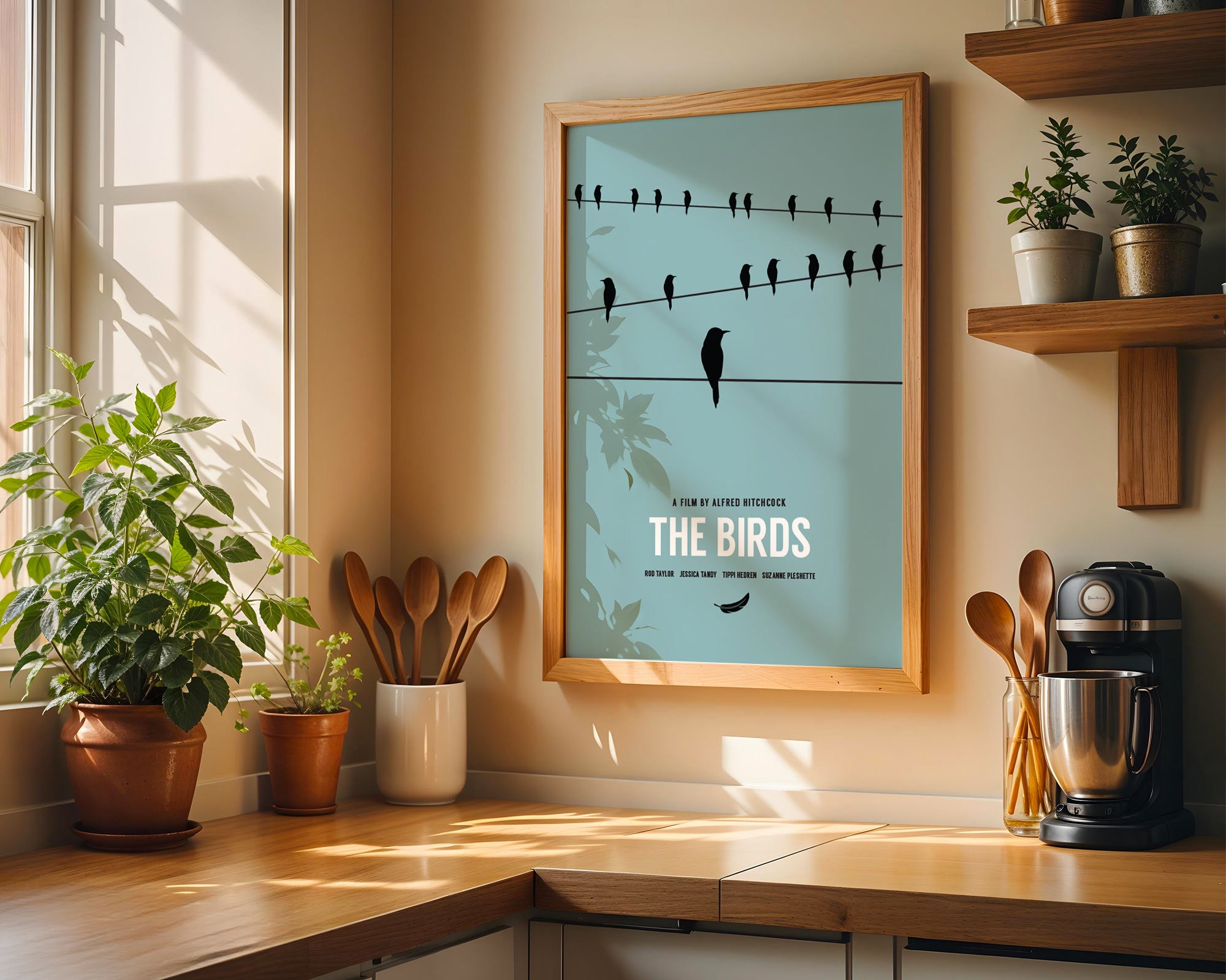 Framed poster of 'The Birds' movie poster in a kitchen setting with plants and kitchenware.