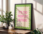 Framed poster with 'It's too peopley outside' text on a wall with plants and a window.
