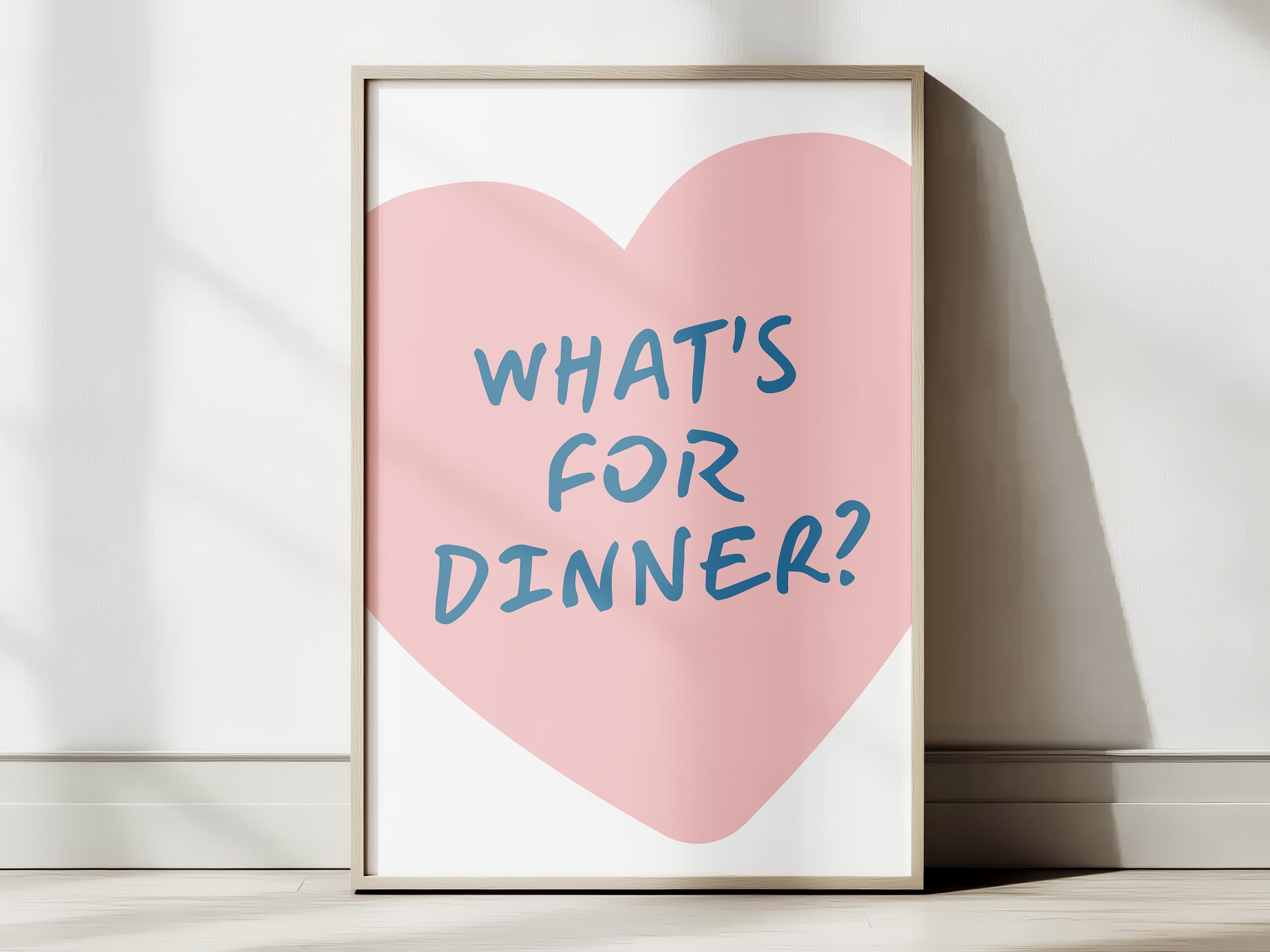 Framed print with a pink heart and blue text on a white surface