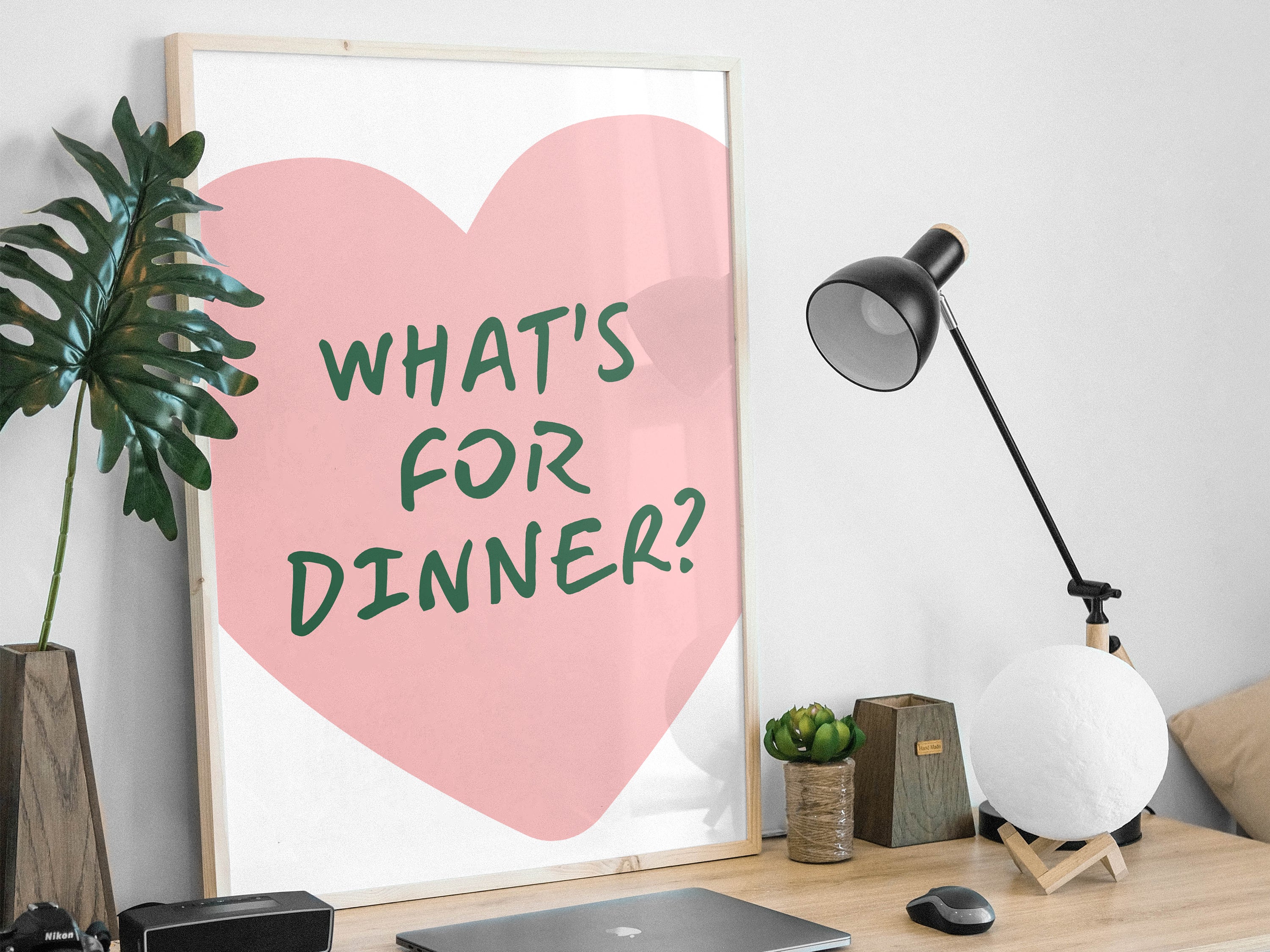 Heart-shaped poster with 'What's for dinner?' text in a modern office setting.
