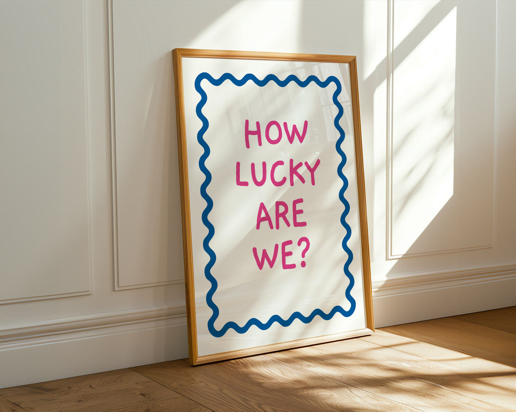 Framed poster with 'How Lucky Are We?' text on a wall.