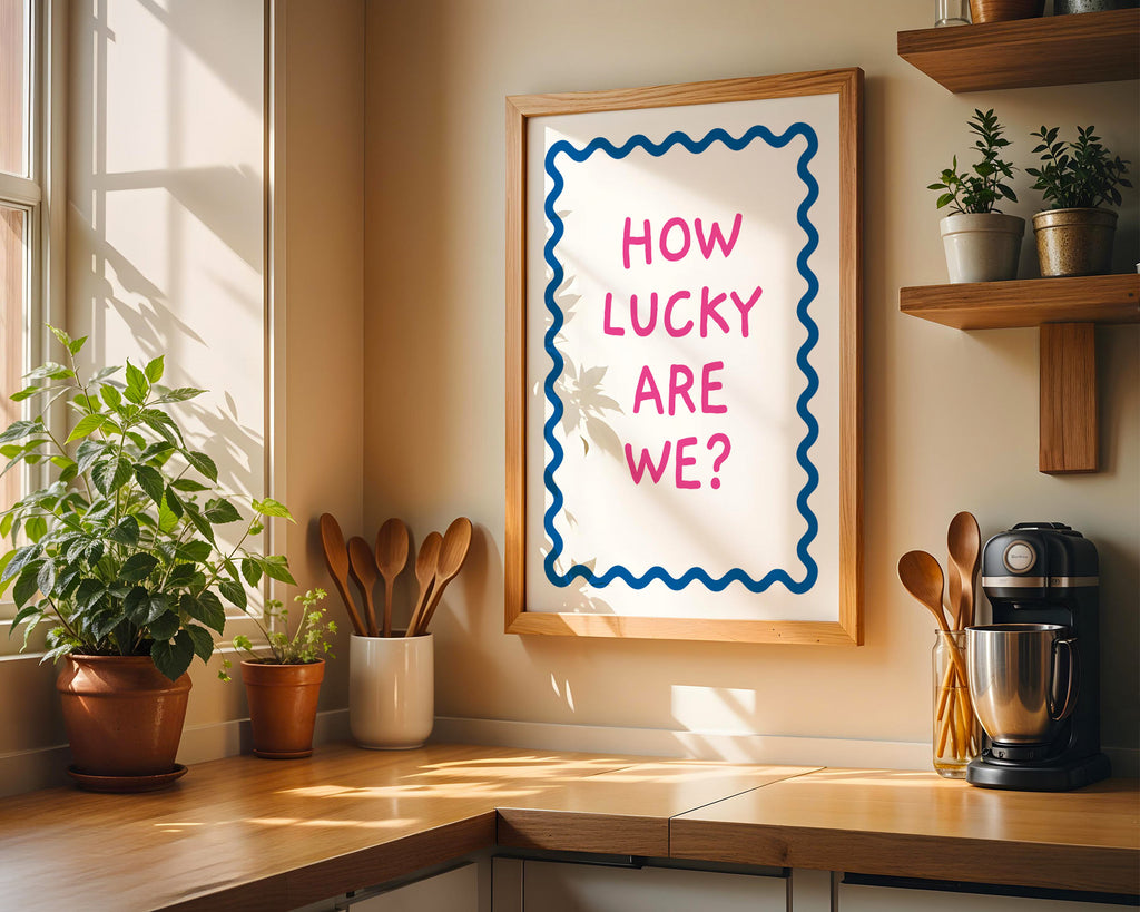 Kitchen corner with a framed poster reading 'How Lucky Are We?' on a wall.